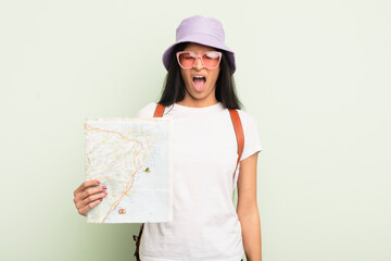young pretty hispanic woman shouting aggressively, looking very angry tourist and map concept