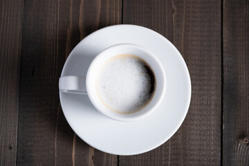 Cafe espresso macchiato layered coffee in a see through white glass coffee cup.