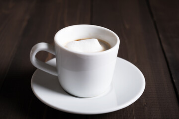 Cafe espresso macchiato layered coffee in a see through white glass coffee cup.