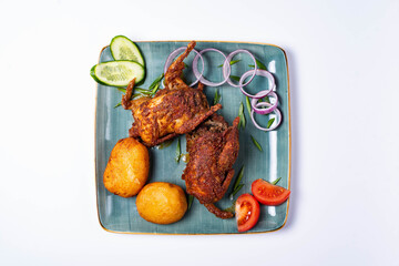 two fried quails with potatoes and fresh cucumbers, tomatoes and onions. on a white background