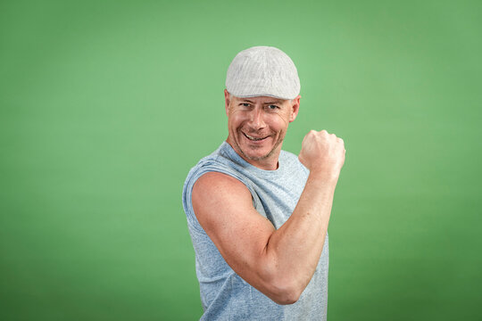 frenchman with gray cap and gray shirt against green background