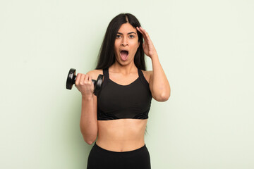 young pretty hispanic woman looking happy, astonished and surprised. fitness concept