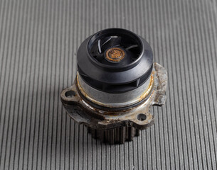 Old car pump on a gray background. The concept of repair and replacement of the pump. Automotive...