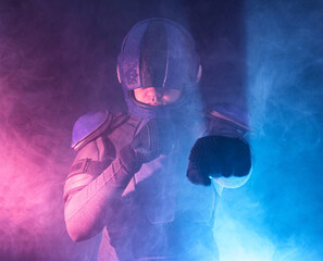 Male robot cop waves and punches his fits in dark. Halfman is ready for fight. Bionic cyborg looks...