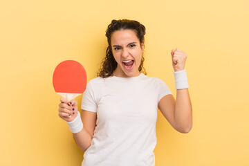young pretty hispanic woman shouting aggressively with an angry expression. ping pong concept
