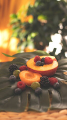 Summer fruity berry background. Table with berries and fruits. Summer breakfast, vacation, morning, sun. Berries, raspberries, blackberries, gooseberries. Vase with berries and fruits. 