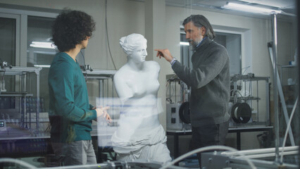 Middle aged men in casual outfits discussing plastic classic statue while standing near modern 3D printers behind glass in professional design studio.