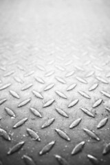Iron plate pattern metal grid steel sheet floor texture. Rusty steel plate black and white BW texture and perspective background with copyspace. Old grungy metal floor of steel sheet metallic.