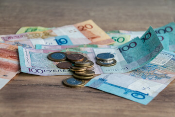Belarusian paper money and coins on a wooden background close-up. Belarusian currency. Cash....