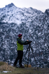 Man taking a photo on tripod in snowy mountain