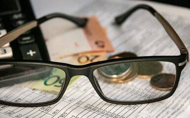 Glasses, Belarusian money, a calculator and a receipt for payment of housing and communal services...