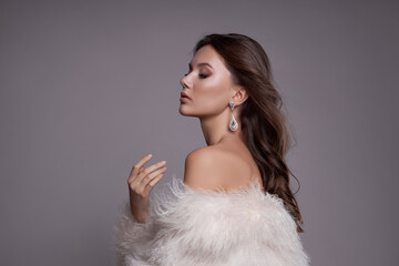 Beauty art portrait of a beautiful woman with long hair, white fur coat with long faux fur....