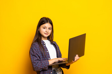 Portrait of attractive girl holding laptop copy space wow solution isolated over bright yellow color background