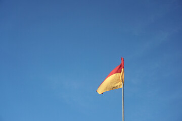 A red over yellow flag at beach signifies a recommended swimming area that has lifeguard...