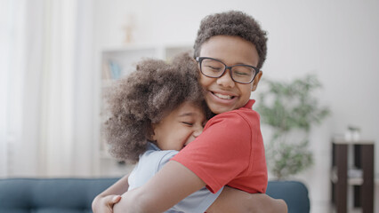 Excited black siblings hugging smiling, friendship between brother and sister