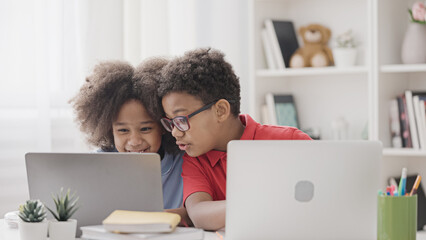 Brother helping with hometask to his little sister, siblings studying at home