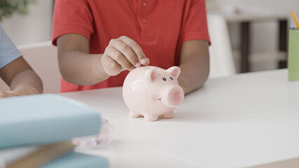 Obraz na płótnie Canvas Kids putting coins in piggy bank, children raising money for charity, finance