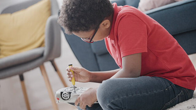 Smart Little Boy Fixing Broken Toy Car With Screwdriver, Skills Development