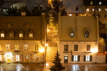Old Buildings Along A Cobble Stone Street Are Lit By Lights At Night.