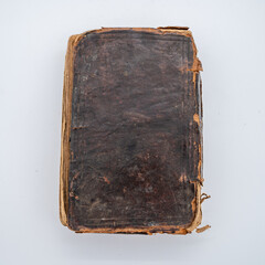 An Old Leather Covered Book Sits Flat. The worn edges lighten the color of the leather.