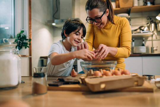 mother and her son preparing food in kitchen