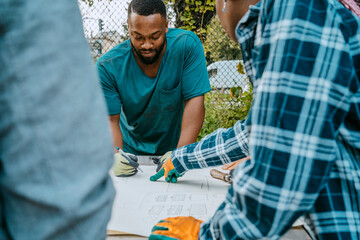 Male environmentalist drawing on paper by volunteers in farm