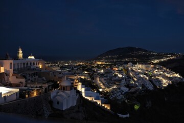 Panoramic view of the picturesque illuminated village of Fira Santorini Greece at night time