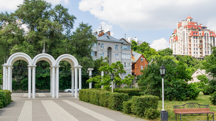 View of Voronezh from Admiralty Square embankment. White arch. Modern and old buildings. Voronezh, Russia - June 17, 2019
