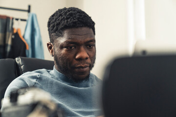 Focused black man working in home on tablet pc - close up shot. High quality photo
