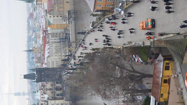 People are walking on Charles bridge, whose rooftops are covered by snow, Prague in the winter