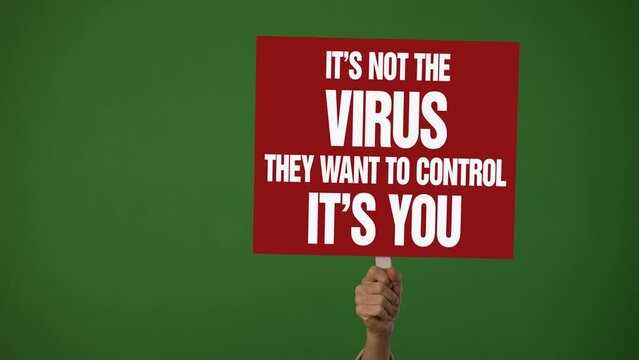 Hand holding sign banner with text They Want to Control You in protest of covid 19 vaccine stop immunization no tax concept on green screen.