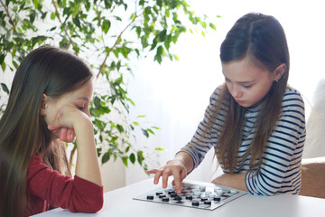 Children play checkers. Board games at home