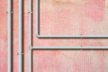 Water and gas galvanized metal pipeline in front of a plaster wall - image with copy space