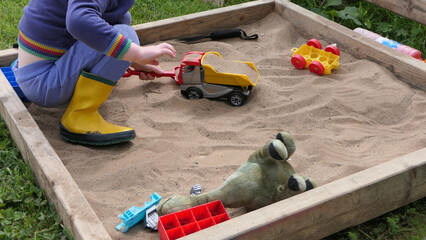Child playing with toys in Sand Pit