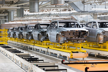 Photo of automobile production line. Modern car assembly plant. Modern and high-tech automotive industry. Conveyor of auto bodies