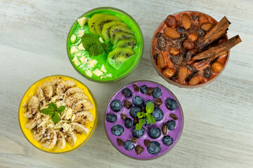 Smoothies or puddings with kiwi, bannas, blueberries and chocolate with almonds and hazelnuts in a crystal bowls.Top view image