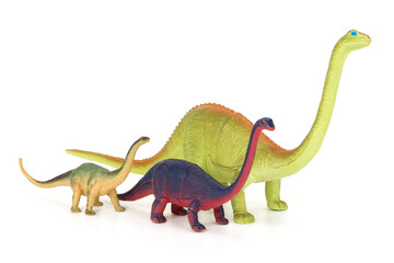 Three toy dinosaurs isolated on completely white background.
