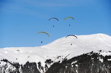 Paragliders over snow covered mountain in winter 