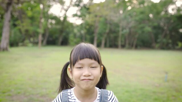 Portrait of young happy asian little girl have fun in the park. Close up smile face girl. Beautiful little girl 7 years old has lost milk teeth. Loss of milk teeth, replacement of permanent teeth.