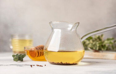 Buckwheat tea and granules with honey, light grey background. Healthy buckwheat tea, Ku Qiao seeds. Healthy food.