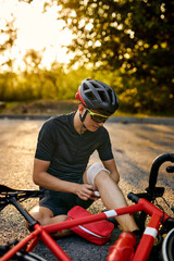 biker fell from bike, using bandage from first aid kit to help himself. Bicycle accident. active...