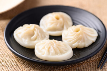 Xiao long bao, small Chinese steamed bun filling with minced pork on black plate
