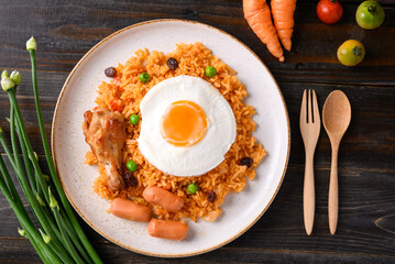 Fried rice with chicken, sausage and fried egg on wooden background, Table top view