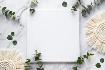 WIntertime mockup with blank square canvas, copy-space. Fresh eucalyptus leaves and twigs. Top view...
