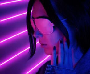Close-up face of a young woman in pink glasses in neon pink light. Concept synthwave or retrowave.