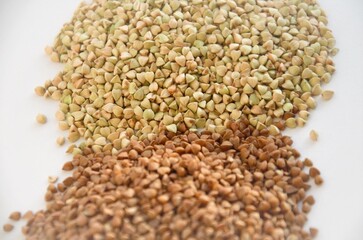 cereals of buckwheat and green unboiled buckwheat on a white background