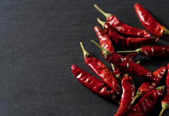 Dried chili peppers placed on a black background.