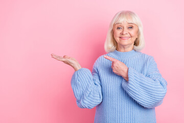 Photo of senior woman indicate finger promo select decision promoter isolated over pink color...