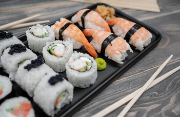 Sushi with rolls on the black plate. Fresh shushi.