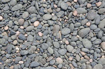 background of grey stones on the beach, large and small, pattern